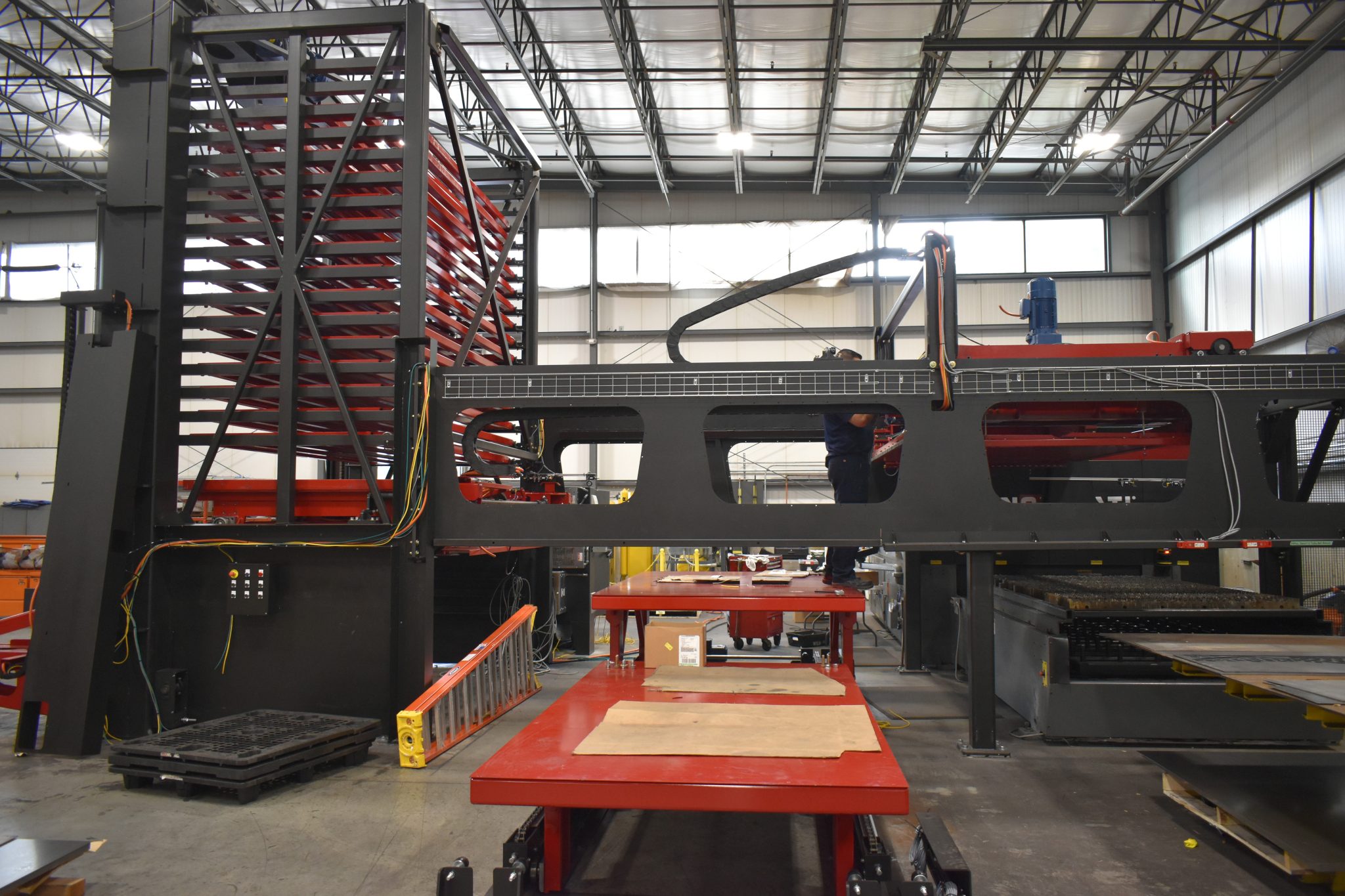 An industrial manufacturing facility featuring a large, complex automated material handling and cutting system.